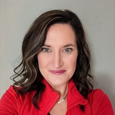 Jodi Leininger-Hussey smiling at the camera while wearing a red jacket